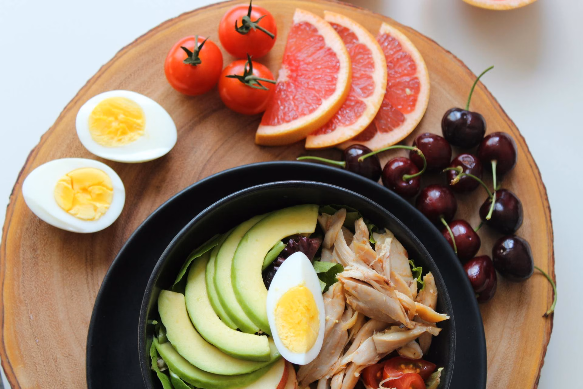 A composed keto plate with eggs, avocado, cured meats and low-sugar extras