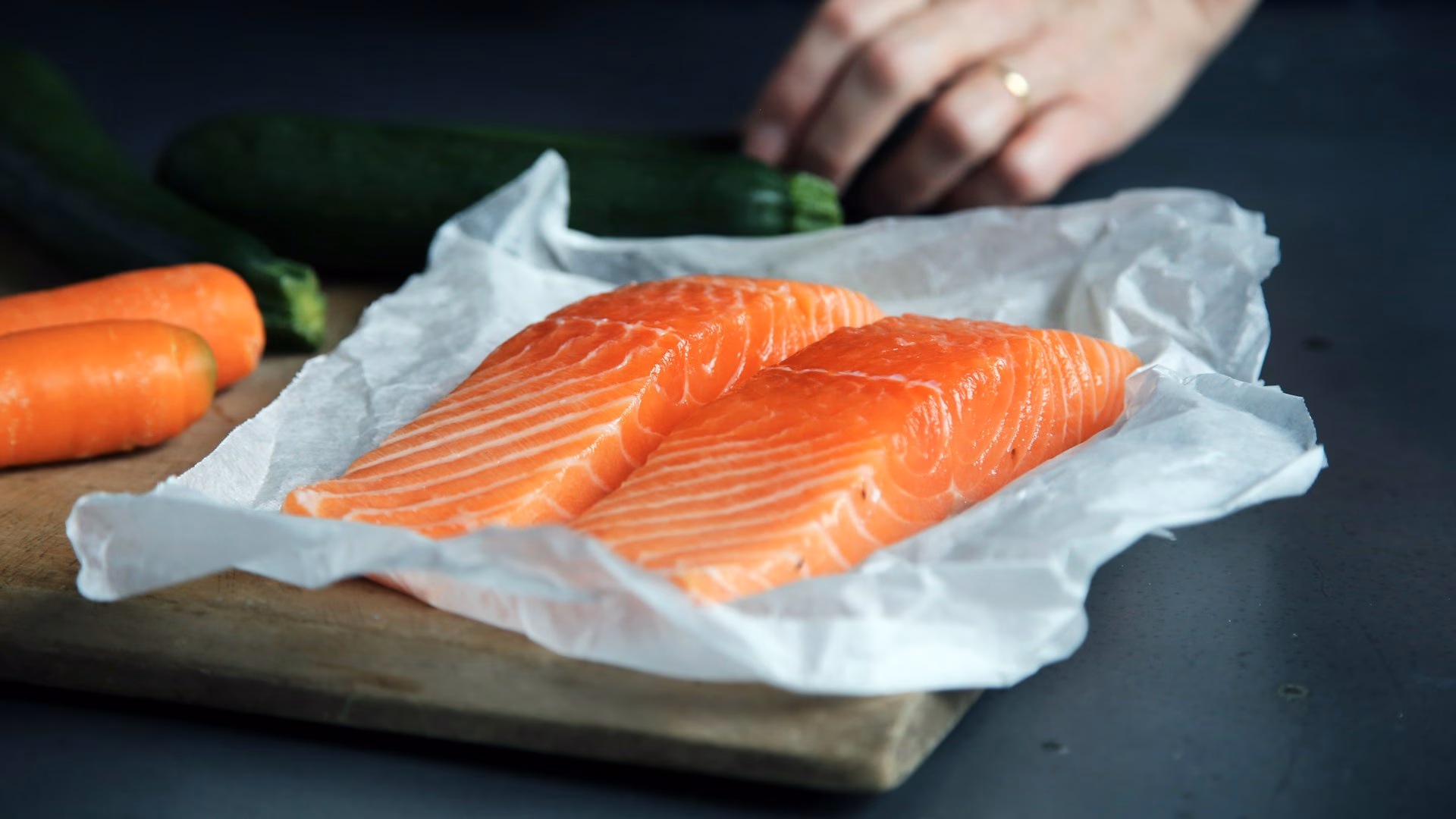 Two fresh salmon fillets on parchment paper
